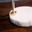 The white marble foot with grey veins provides support and contributes to the design.