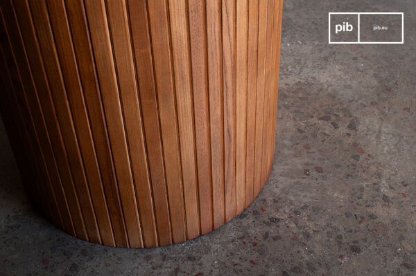 Een ovale tafel waar hout en messing uitnodigen om elk moment te verlengen