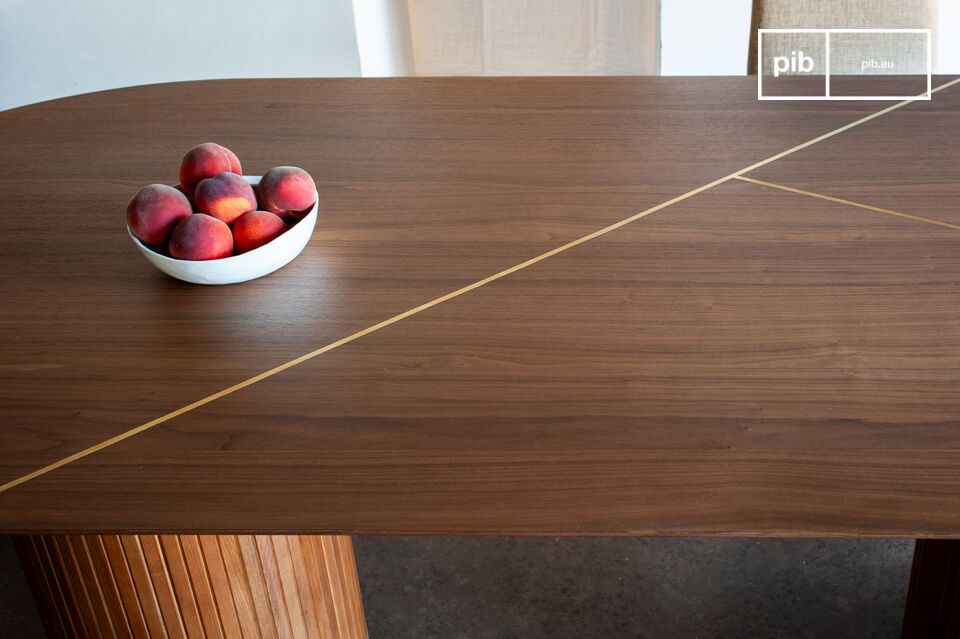 De ovale tafel Ligna combineert de diepte van mat notenhout met de subtiele glans van twee ingelegde
