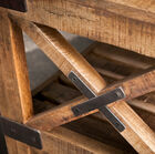 The wooden cross structure is reinforced with metal strips.