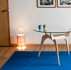 Elegante tafel met glazen blad en essenhouten onderstel.#