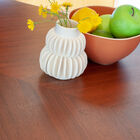 The matt gold base contrasts perfectly with the dark walnut of the top