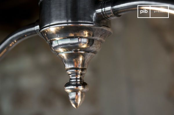 Le pavillon supérieur présente une silhouette travaillée, ponctuée d'une pointe décorative, qui donne à la suspension un style raffiné et un cachet presque architectural.