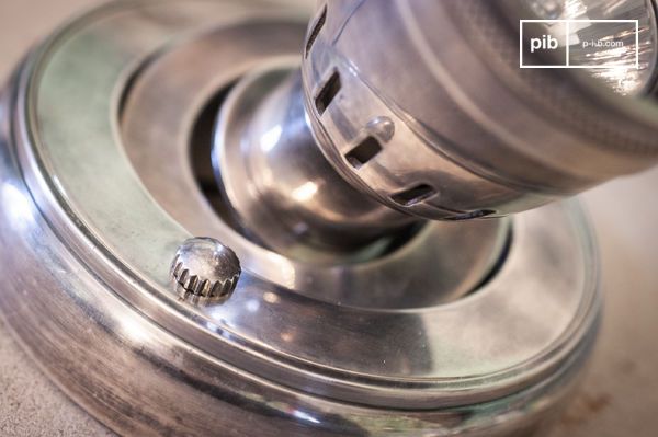 Le support circulaire présente des cerclages concentriques et une molette crantée qui souligne son esprit technique.