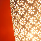 The lampshade features delicate flowers cut from ceramic.