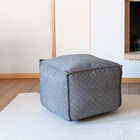 Petit pouf de forme cubique aux motifs ethniques.