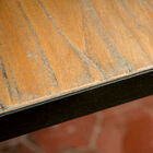 Die leicht unregelmäßige Platte aus gerilltem Ulmenholz verleiht dem Tisch einen urigen