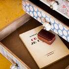 Ce petit meuble rassemble trois tiroirs recouverts de papiers peints d'inspiration florale qui