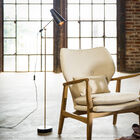 The large reading light rests on a stable black round metal foot.