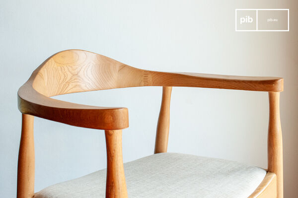 Questa poltrona tipicamente scandinava gioca sulla somiglianza tra il legno chiaro e la seduta in