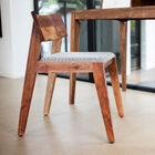 Original y pequeña silla de madera oscura.