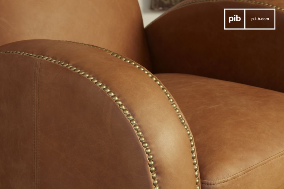 Los tonos camel del sillón se acentúan con un clavado de latón cepillado.