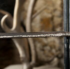 a slightly white patina, applied on a textured metallic finish.