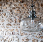 Le généreux bulbe en verre transparent est associé à un porte ampoule d'inspiration art déco.