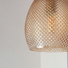 La finition ambrée de l'abat-jour diffuse une lumière chaleureuse.