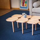 Table basse en bois clair originale avec un assemblage de plateaux.