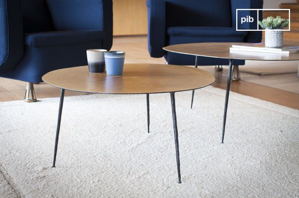 Une table tripode aux pieds effilés et au plateau affûté.