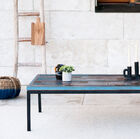 La table combine un plateau en bois recyclé à un piètement en métal noir pour un style bohème authentique.