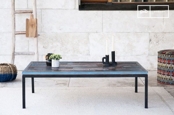 La table combine un plateau en bois recyclé à un piètement en métal noir pour un style bohème authentique.