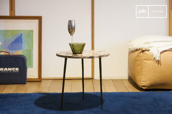 Une table d'appoint associant un marbre précieux à un métal texturé.