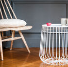 Belle table d'appoint blanche à la structure géométrique.