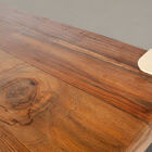 Cette table de repas associe un plateau en teck massif recyclé à une structure en acier plié