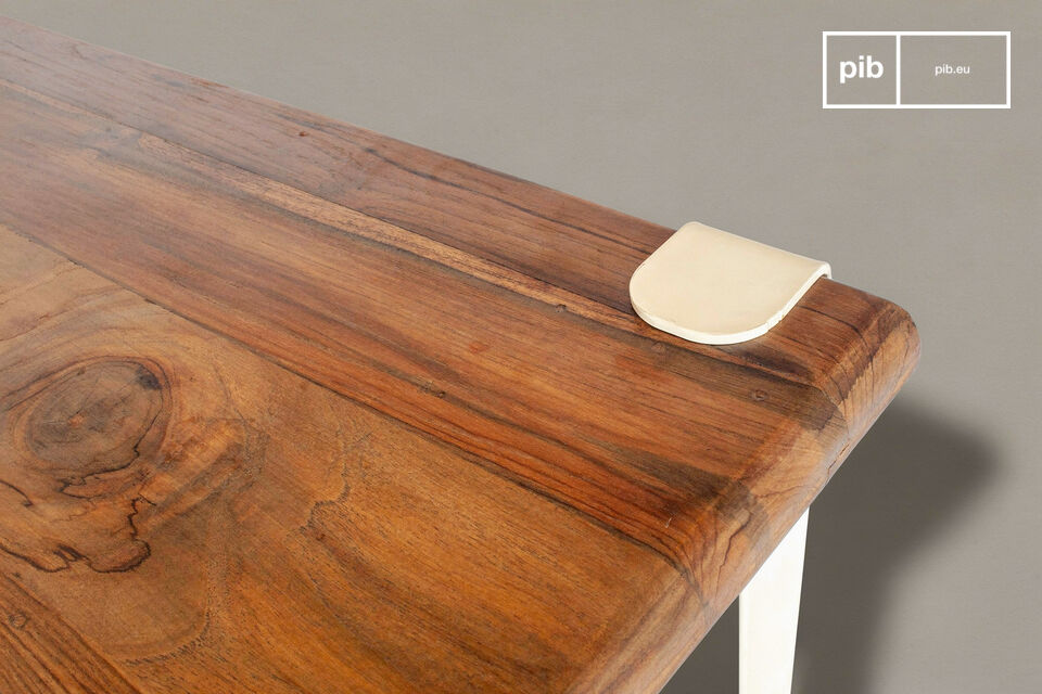 Cette table de repas associe un plateau en teck massif recyclé à une structure en acier plié