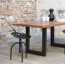 La table affiche une silhouette massive et harmonieuse qui renforcent son caractère industriel.