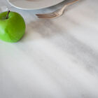 Le joli plateau est rond en marbre blanc, veiné de gris.