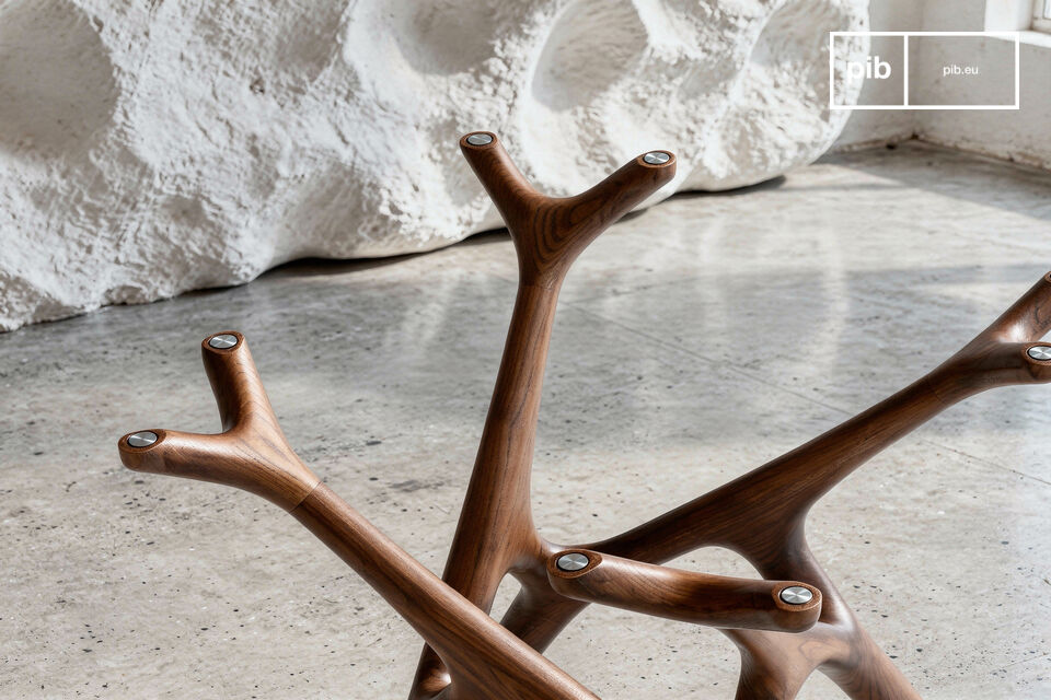 Le piètement en bois massif de cette table dessine un entrelacs de branches stylisées d’une