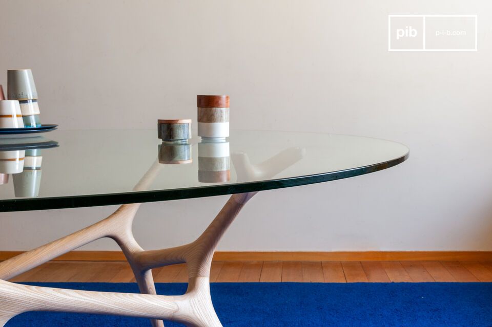 Le fin plateau rond en verre s'efface avec élégance.