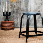 Precioso taburete de taller de metal negro.