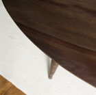 Il tavolo ha un magnifico piano in legno scuro.