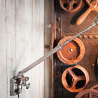 Bolts and clamping screws punctuate the telescopic brass rod covered with a varnished silver finish