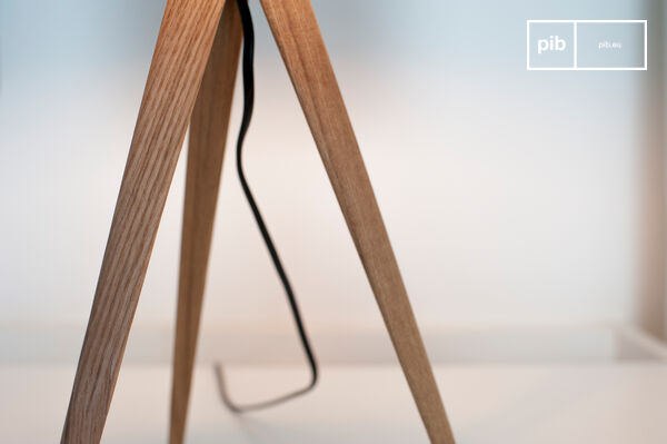 Stativfuß aus hellem Holz.