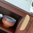 De rijke en diepe tinten van het walnoothout worden geaccentueerd door mat vergulde koperen