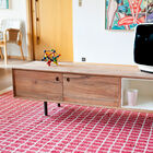 The cabinet is placed on 4 tubular legs in grey metal.