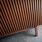 The absence of handles reinforces its clean look, while the dark wood brings depth and character