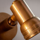 Compact en doordacht onderscheidt de wandlamp van koperkleurig messing uit de Bax-collectie zich