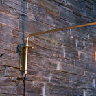 Schöne goldene Wandlampe mit freiliegender Glühbirne.