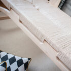 The three-seat seat is entirely woven from unbleached rattan.