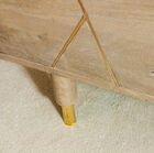 The chest of drawers has a pretty golden base.