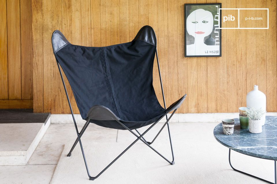 Fauteuil van zwart canvas en met een matte cilindrische metalen structuur.